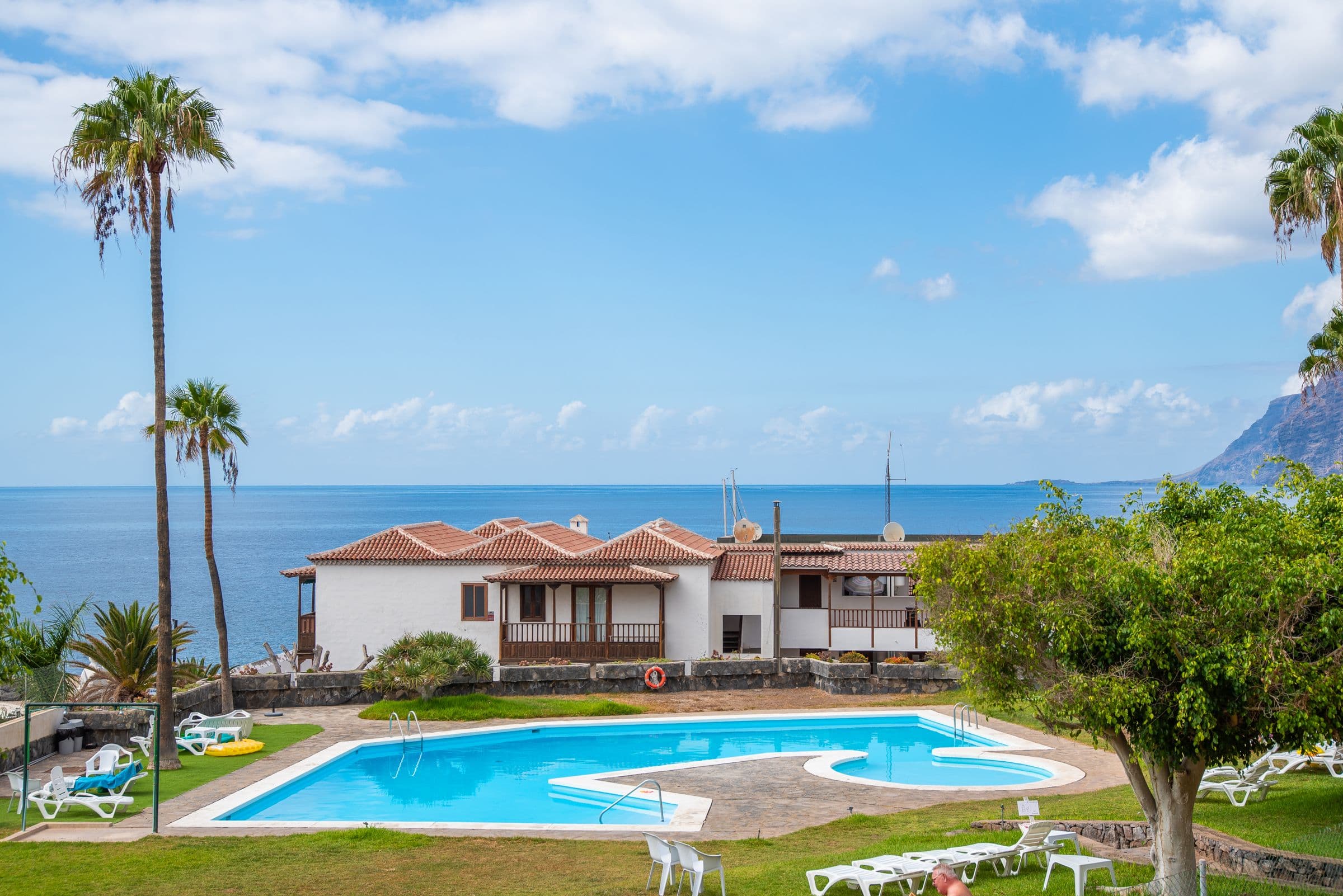 Pool in the complex with palms and sea